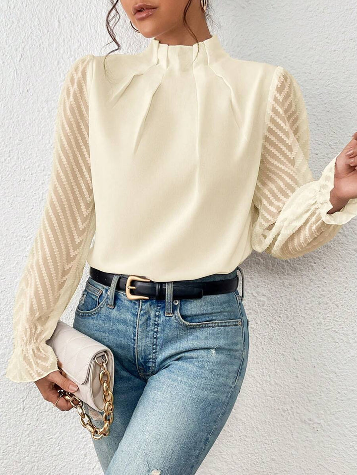 Stilfuld dametop med høj hals. De gennemsigtige ærmer tilføjer et sofistikeret touch til denne elegante festbluse.