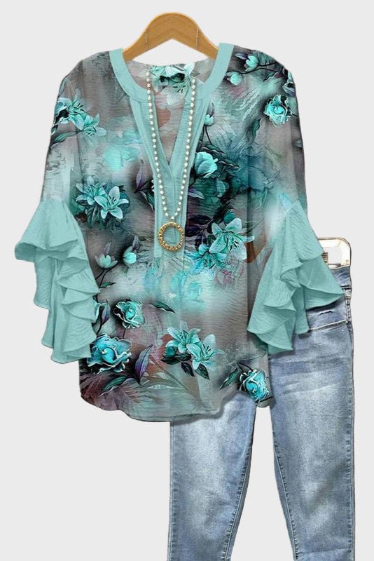 Elegant damebluse med kunstnerisk blåt print og feminine flæseærmer. Mønstret boheme-stil til hverdag.