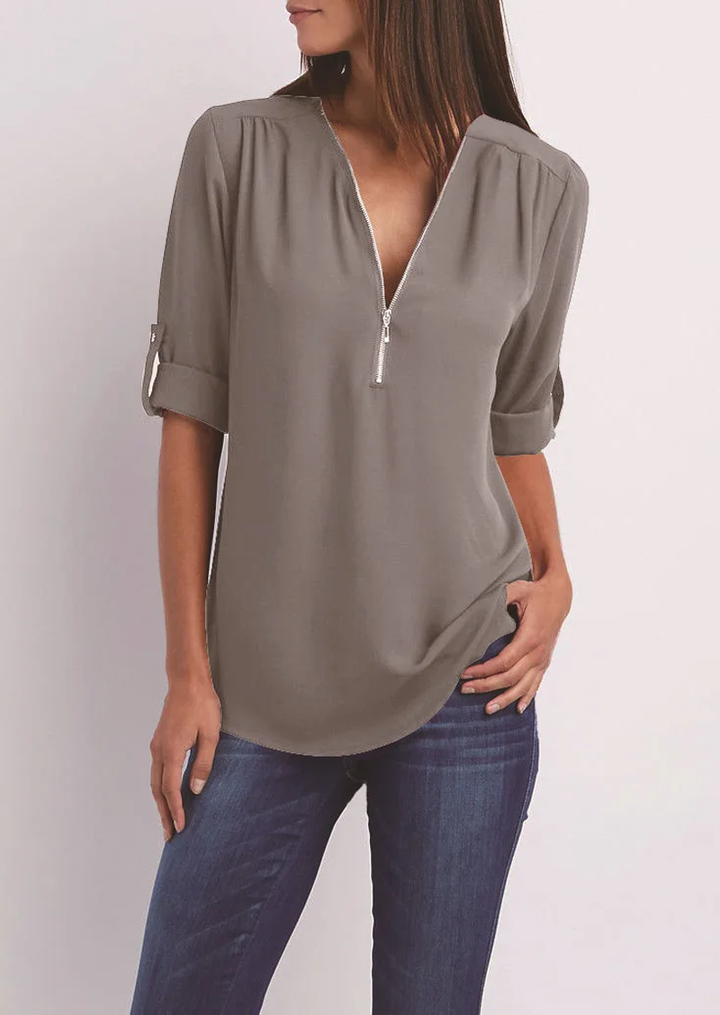 "Elegant damebluse med lynlås og blødt materiale, fås i flere farver. Perfekt til både hverdags- og festbrug."