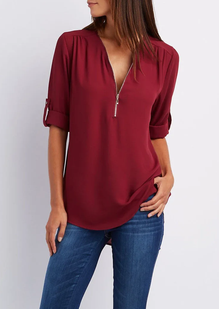 "Elegant damebluse med lynlås og blødt materiale, fås i flere farver. Perfekt til både hverdags- og festbrug."