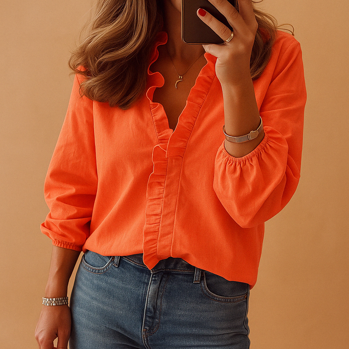 Elegant damebluse med V-hals og flæser. Feminin og stilfuld top, perfekt til både hverdag og fest.