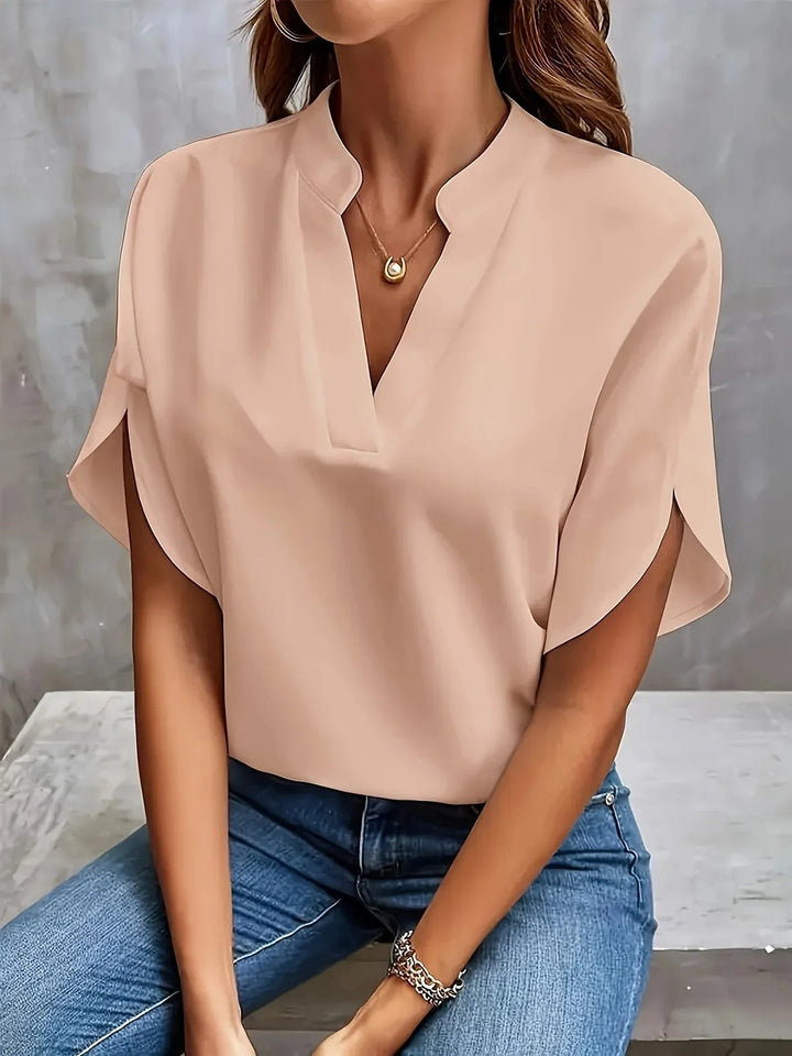 Feminin damebluse med V-hals og kasketærmer. Moderigtig top til kvinder, skøn til hverdag og fest.