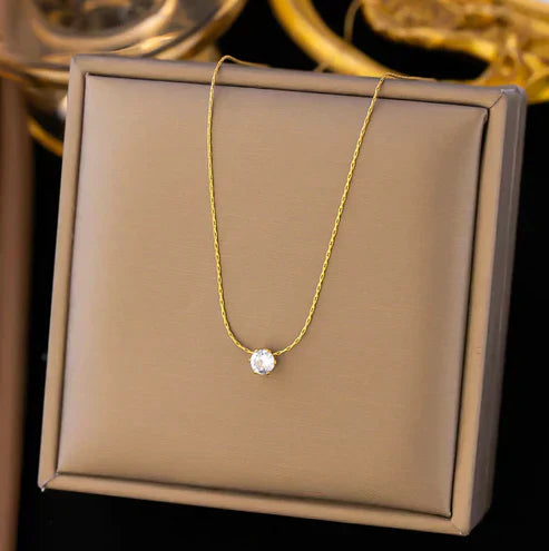 Elegant damehalskæde i guld med skinnende solitaire krystal. Tidløst, minimalistisk smykke til kvinder.