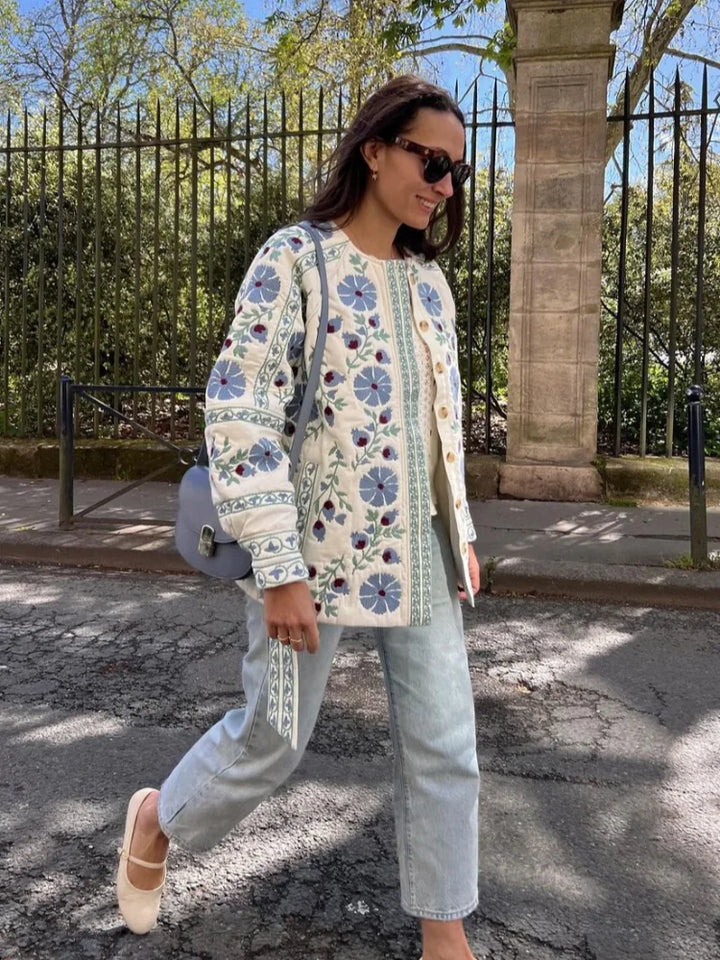 "Elegant damejakke med broderet blomstermønster, rund hals og lange ærmer. Perfekt til et feminint og moderne look."