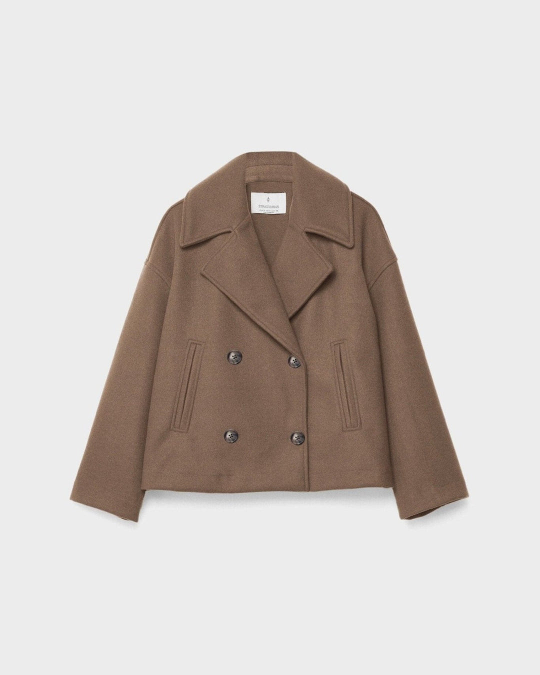 Smuk model i en kort, dobbeltbrystet damejakke, der udstråler elegance og moderne stil.