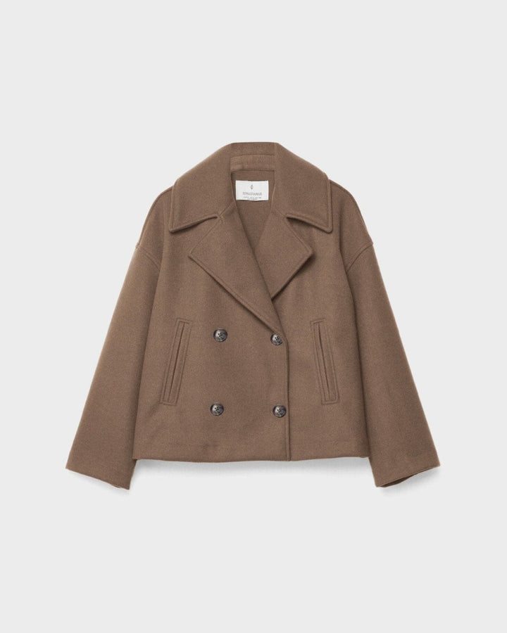 Smuk model i en kort, dobbeltbrystet damejakke, der udstråler elegance og moderne stil.