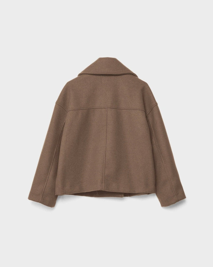 Kravedetalje på en eksklusiv dobbeltbrystet damejakke. Viser klassisk design og håndværkskvalitet.