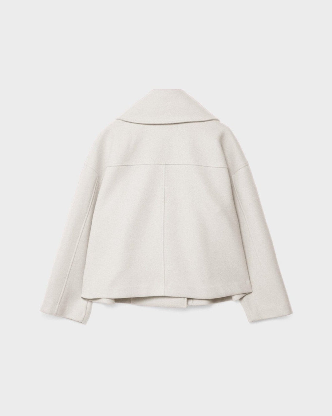 Nærbillede af stoffet på en eksklusiv dobbeltbrystet damejakke, der viser kvalitet og håndværk.
