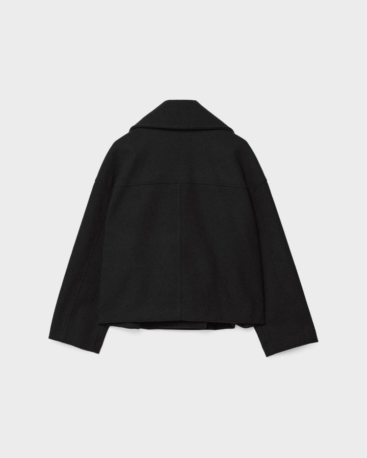 Kort, elegant dobbeltbrystet damejakke set fra siden. Fremhæver det moderne snit og eksklusive look.