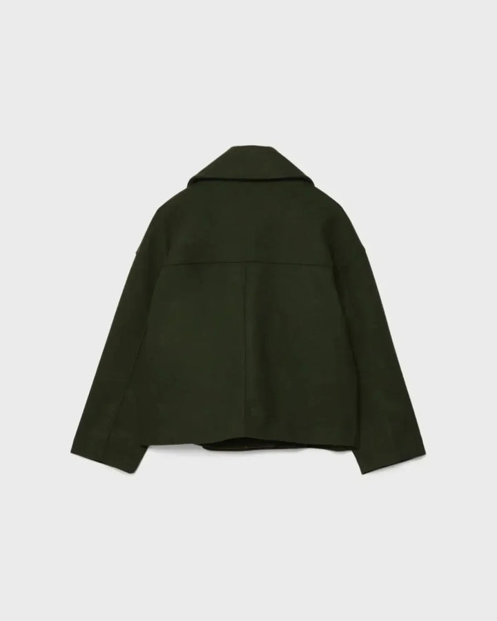 Dobbeltbrystet damejakke hængende. Viser det korte, elegante snit og designets klassiske linjer.