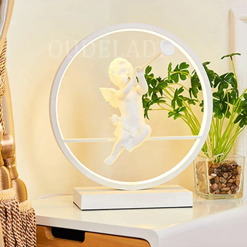 Stilfuld rund bordlampe med engeldesign og USB-opladning. Giver varmt LED-lys, ideel til soveværelse eller stue.