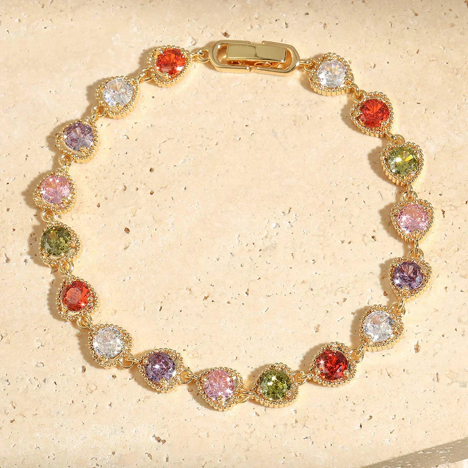 Elegant farverigt dame tennisarmbånd i guld med skinnende multifarvede zirkonia sten til fest eller hverdag.