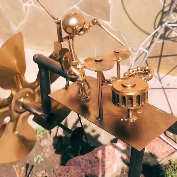 Smuk havekunst: metal vindmølle i elegant guitarform med skinnende guld og sølv finish. Perfekt udendørs.