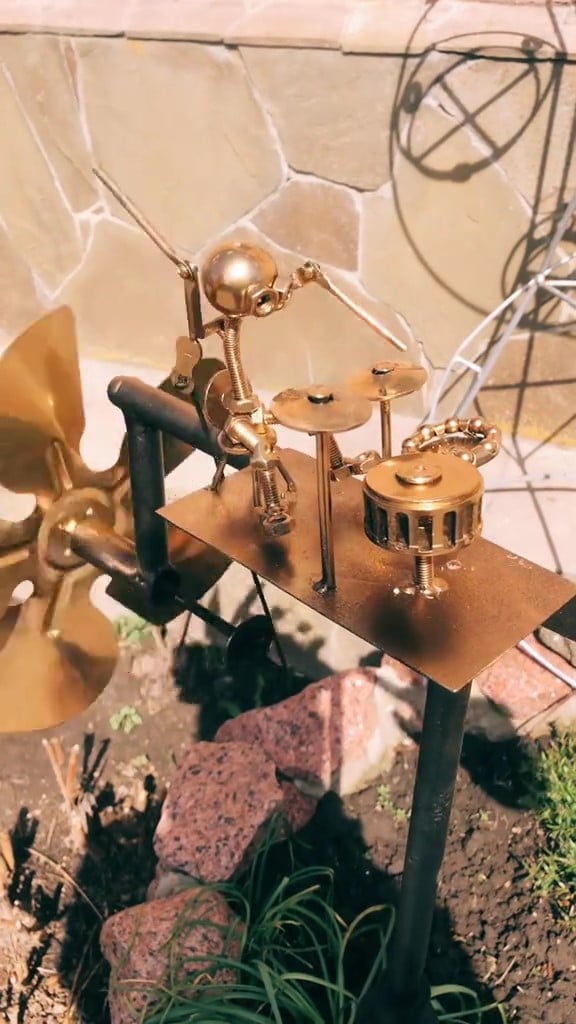 Unik gaveide: guitarformet metal vindmølle. En elegant og holdbar haveudsmykning i guld/sølv.