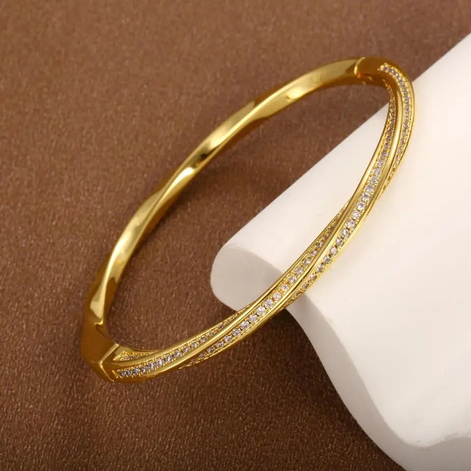 Elegant guld bangle armbånd til kvinder med funklende krystaller. Perfekt damearmbånd til fest og hverdag.