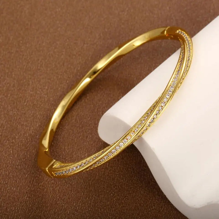 Elegant guld bangle armbånd til kvinder med funklende krystaller. Perfekt damearmbånd til fest og hverdag.