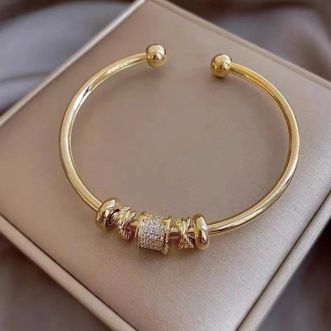 Elegant guld manchetarmbånd til kvinder med fine charms. Luksuriøst damearmbånd, perfekt som gave.