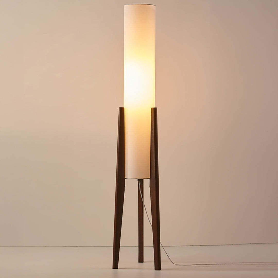"Elegant gulvlampe i valnød med nordisk retrodesign, solid træbase og blød stofskærm, skaber hyggelig belysning."