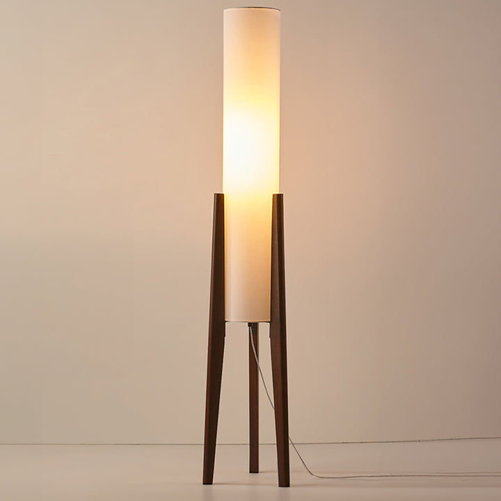 "Elegant gulvlampe i valnød med nordisk retrodesign, solid træbase og blød stofskærm, skaber hyggelig belysning."