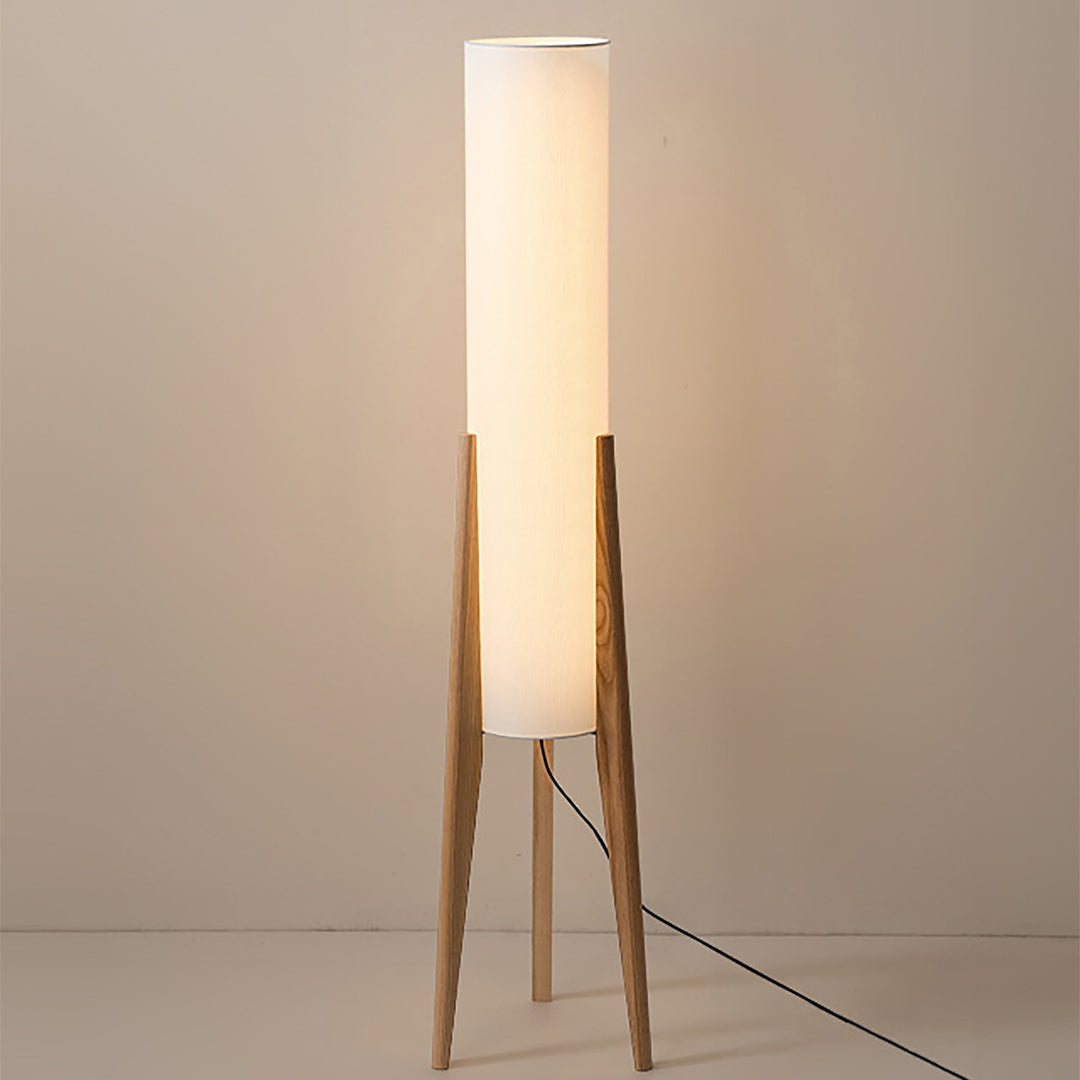 "Elegant gulvlampe i valnød med nordisk retrodesign, solid træbase og blød stofskærm, skaber hyggelig belysning."