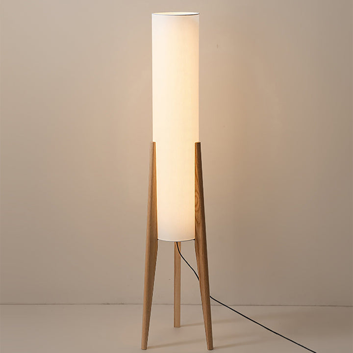 "Elegant gulvlampe i valnød med nordisk retrodesign, solid træbase og blød stofskærm, skaber hyggelig belysning."