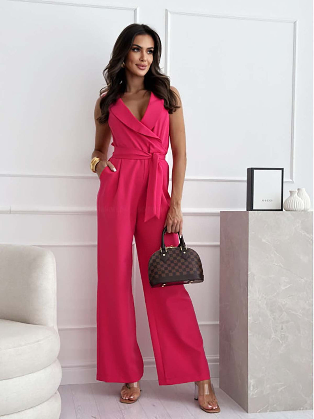 "Elegant jumpsuit med bindebånd, slå-om design og vide bukseben i sort, formsyet pasform til kvinder, forfra set."