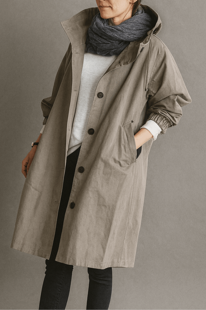 Bagside af klassisk kvinde trenchcoat med slids og elegant fald, ideel som lang forårs- eller efterårsjakke.