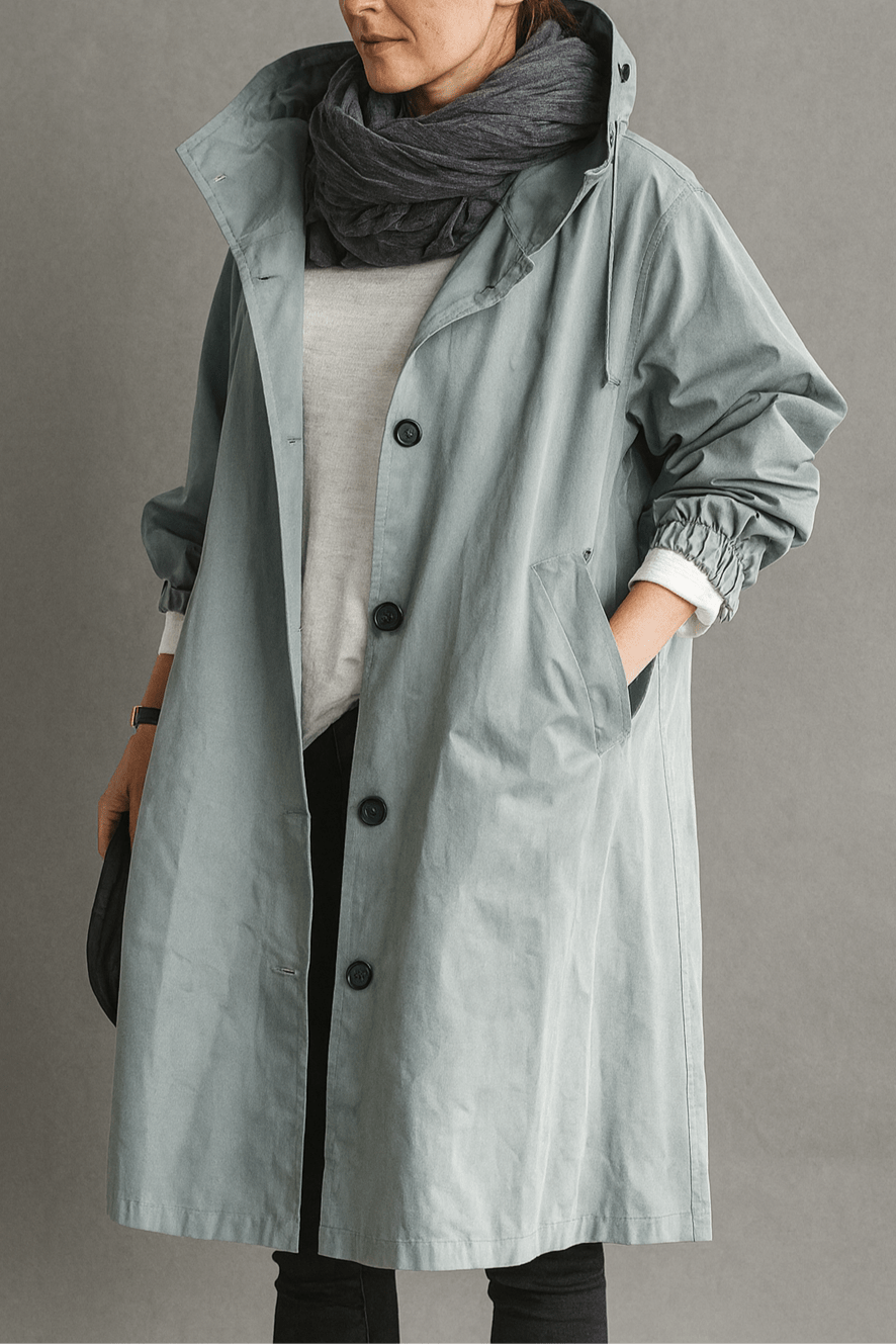 Kvinde iført elegant trenchcoat i siden, fremviser lang, stilfuld silhuet og klassisk overtøj.