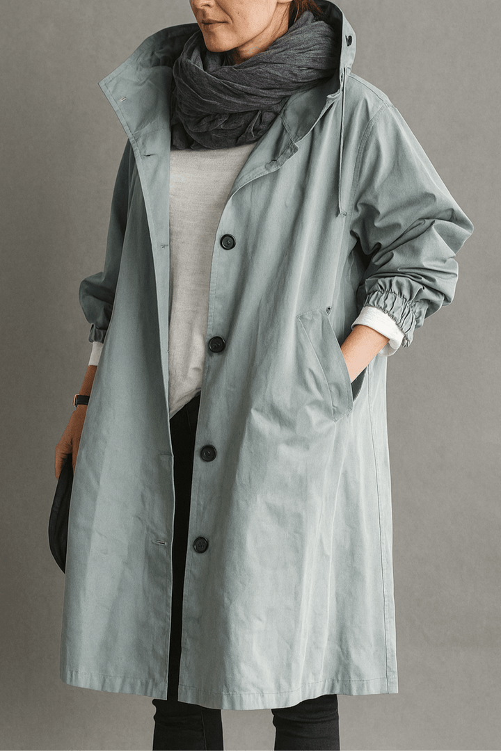 Kvinde iført elegant trenchcoat i siden, fremviser lang, stilfuld silhuet og klassisk overtøj.