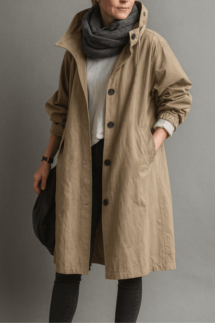 Klassisk trenchcoat til kvinder præsenteret på bøjle, fremhæver elegant design og vejrbestandig kvalitet.