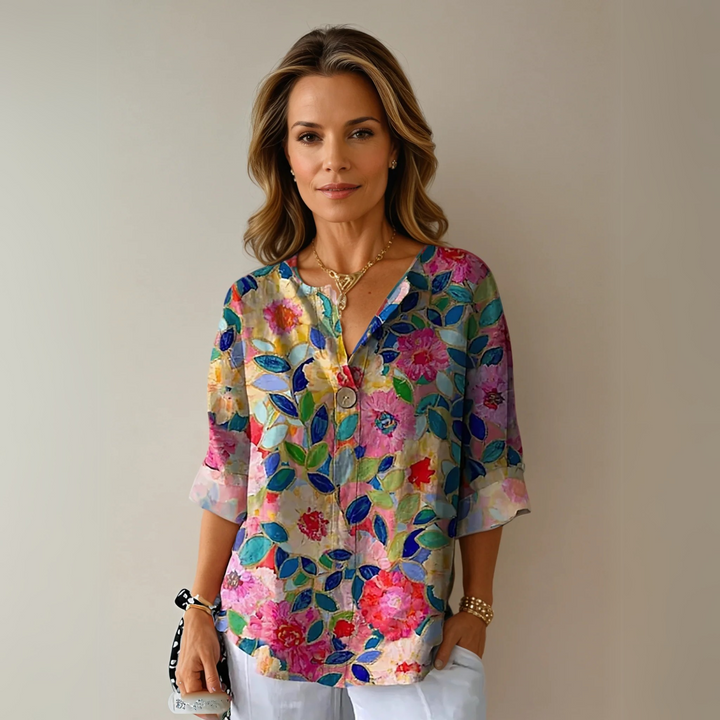 Elegant kvindebluse fra Bymayberry med farverigt blomsterprint, perfekt til sommerstil.