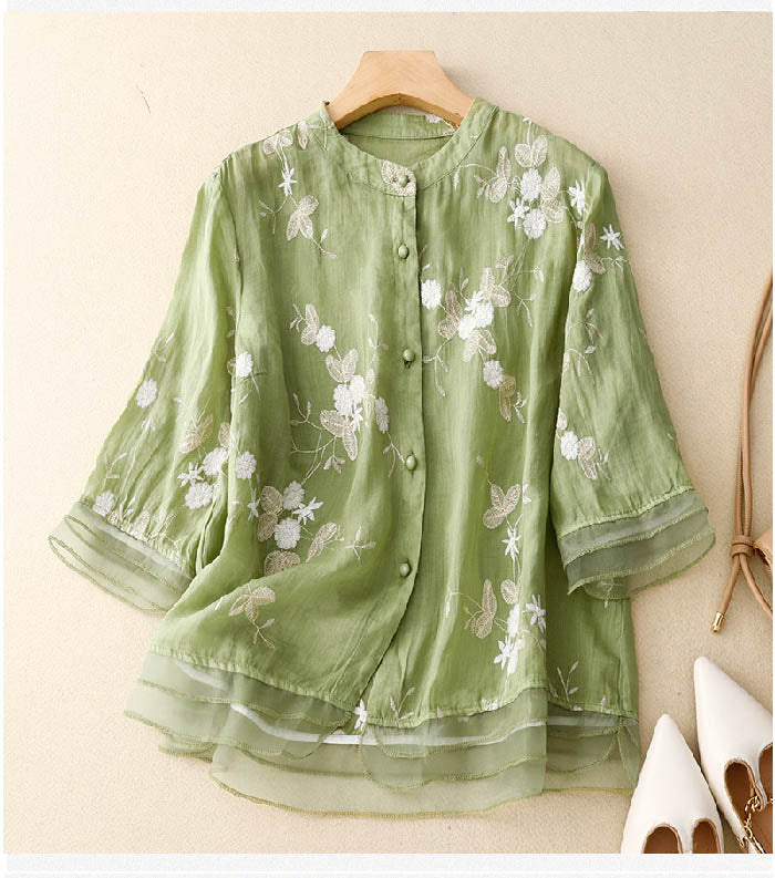 Elegant kvindebluse med farverigt blomsterbroderi, løs pasform til sommer og forår.
