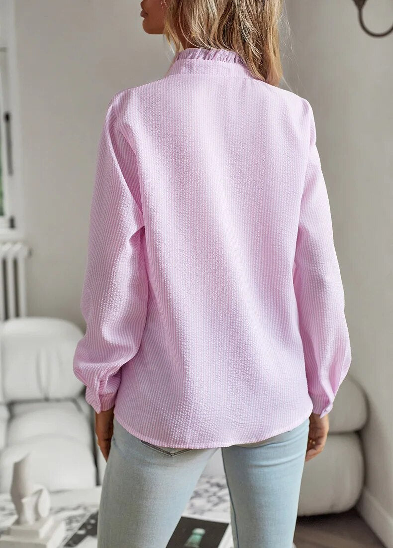Flot knapbluse til kvinder med feminine flæsedetaljer. Ideel for elegant og stilfuld hverdagsmode.