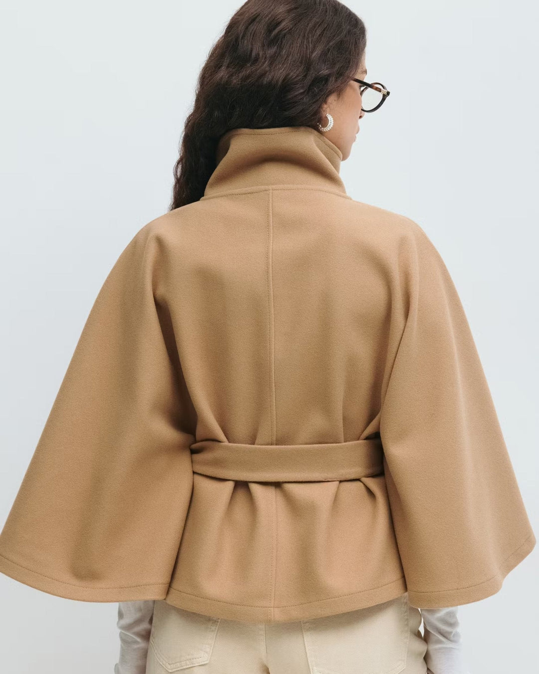 Elegant kvindekappe i lang model med stilfuldt bælte for en defineret silhuet.