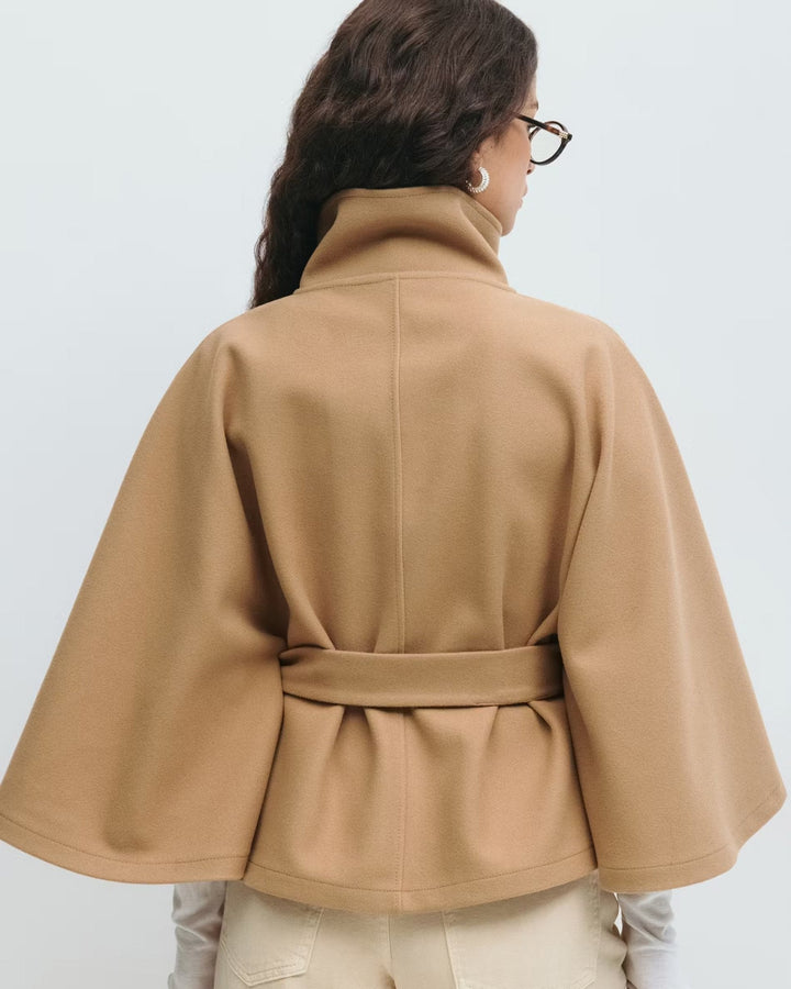 Elegant kvindekappe i lang model med stilfuldt bælte for en defineret silhuet.