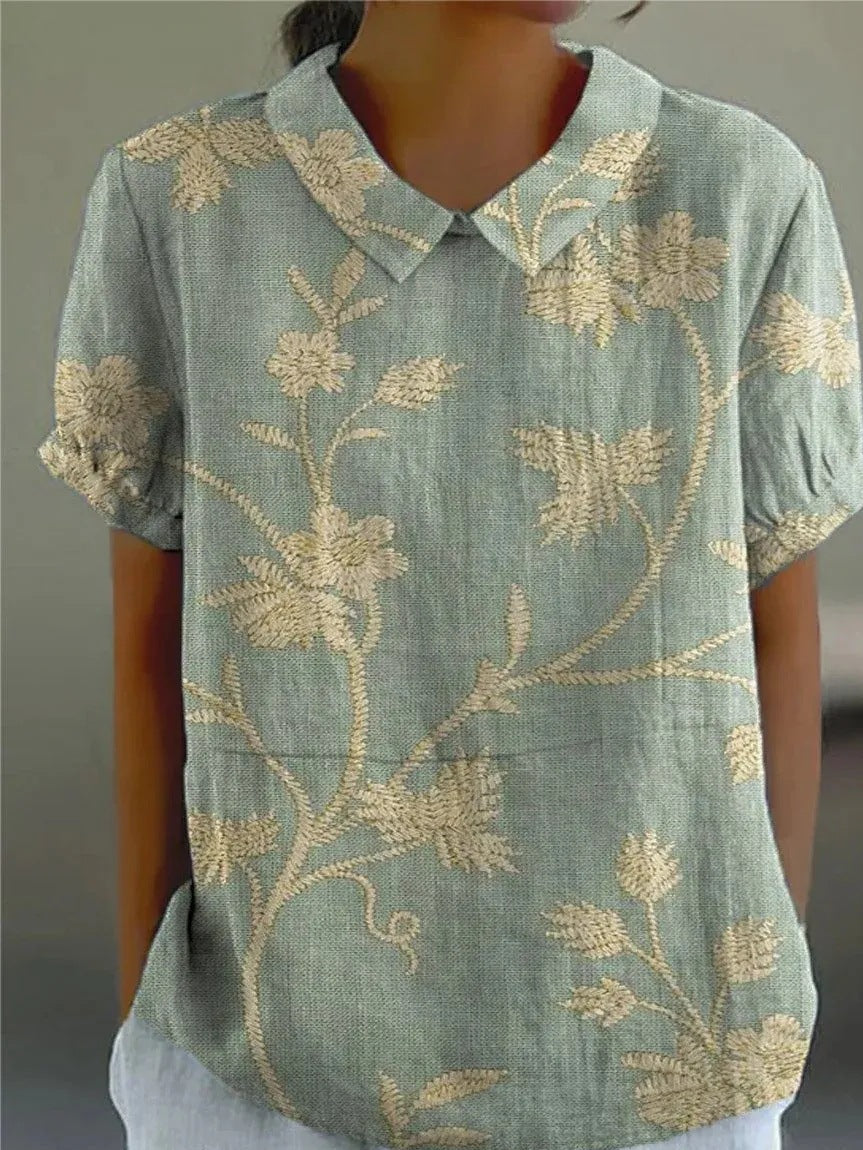 Elegant kvinders blomsterskjorte med farverigt blomsterprint, perfekt til en feminin sommerstil.