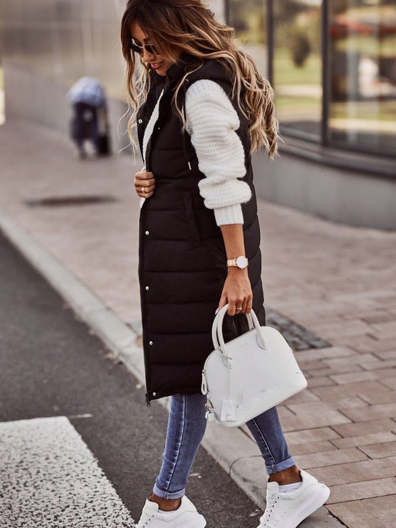 "Elegant kvindevest i quiltet design, knælang og ærmeløs, ideel til vinter, med lynlås og sidelommer for stil og komfort."