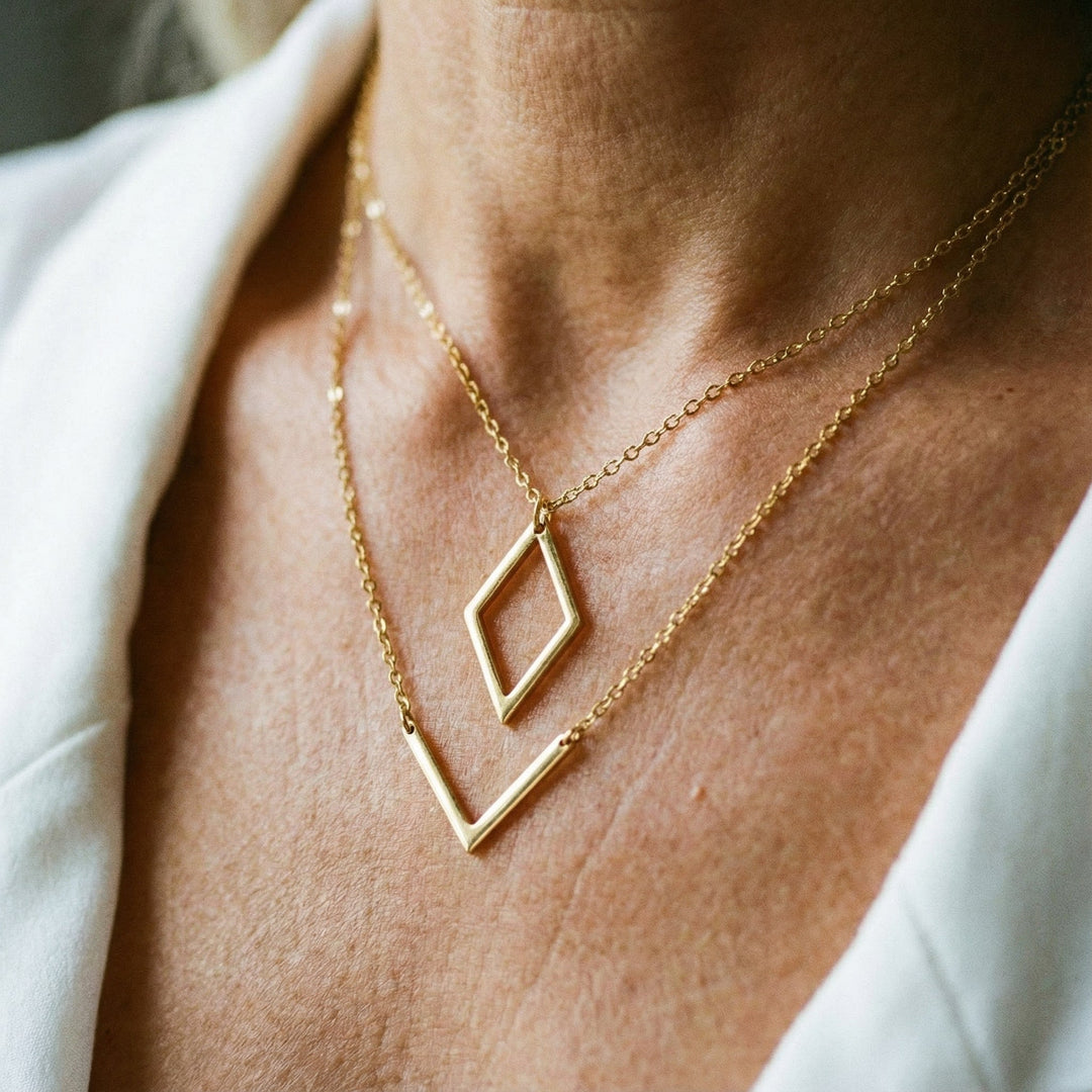 Moderne lagdelt guldhalskæde med skinnende geometrisk diamantvedhæng. Perfekt gave til hende.