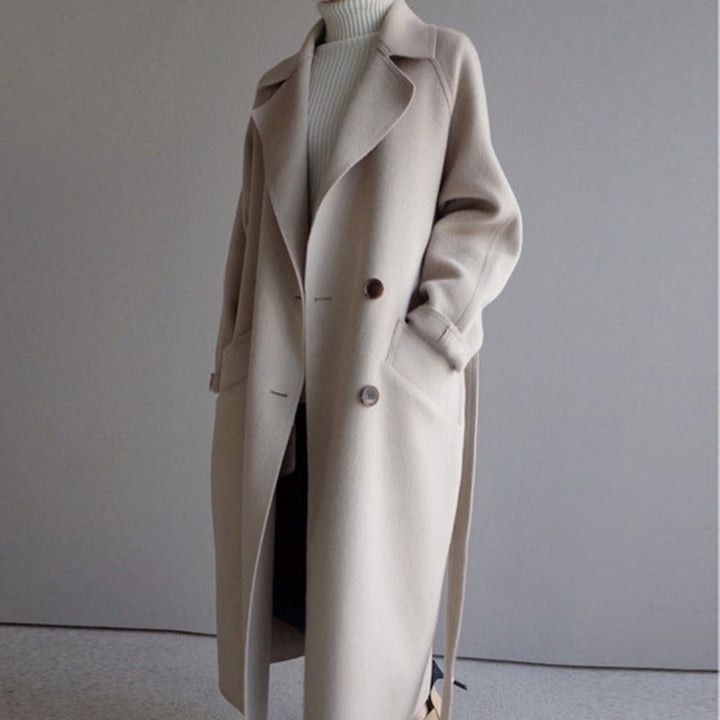Elegant lang beige dame vinterfrakke i klassisk design, ideel til stilfuld vintermode.