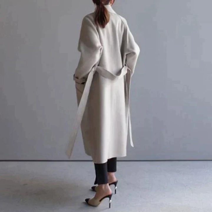 Elegant dame langfrakke i tidløst snit, ideel som varm og stilfuld vinterfrakke i beige farve.