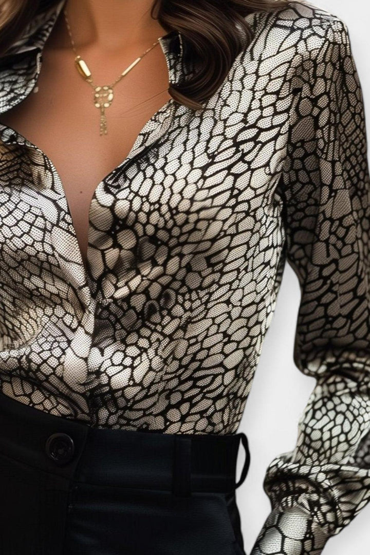 Stilfuld damebluse med unikt print og flatterende V-udskæring. Langærmet design til elegant hverdags- eller festbrug.