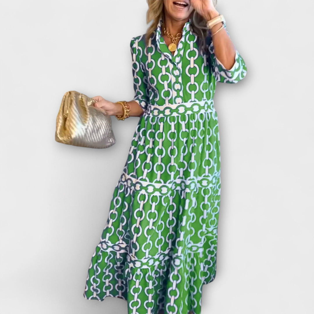 Flatterende midi kjole med unikt kædemønster og trekvart ærmer, en stilfuld og moderne kvindekjole.