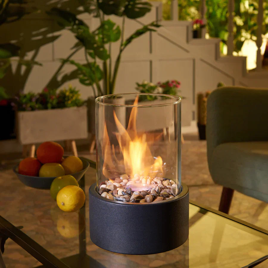 "Elegant moderne bordpejs i glas og metal med levende flamme, perfekt til hyggelige hjem og moderne indretninger."