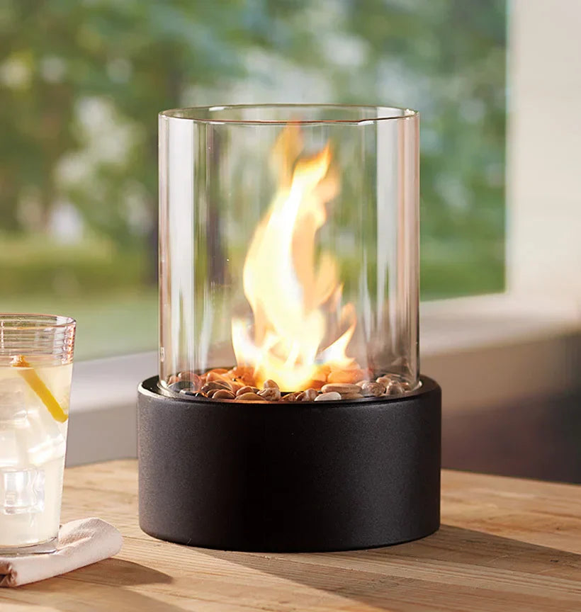 "Elegant moderne bordpejs i glas og metal med levende flamme, perfekt til hyggelige hjem og moderne indretninger."