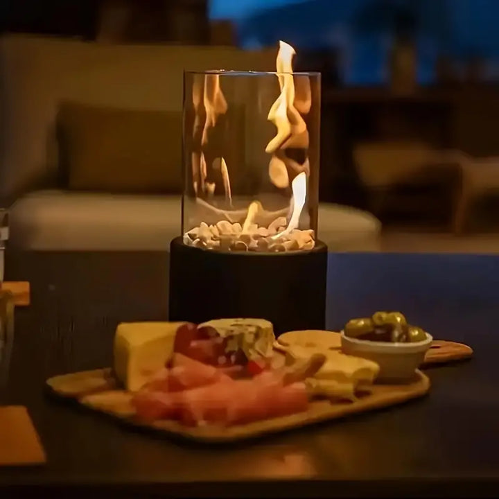 "Elegant moderne bordpejs i glas og metal med levende flamme, perfekt til hyggelige hjem og moderne indretninger."