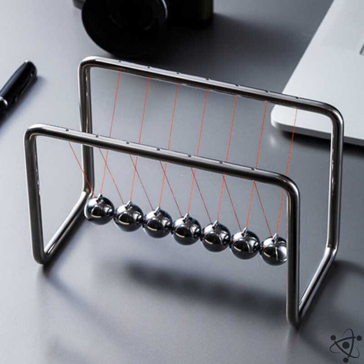 Elegant Newtons Vugge pendul med skinnende stålkugler. Perfekt videnskabelig skrivebordsdekoration og stressaflaster til kontoret.