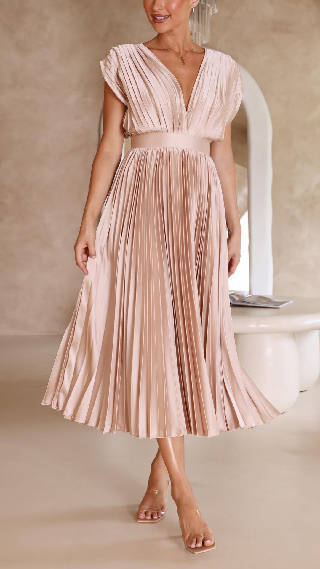 Nærbillede af de fine plisseringer på den elegante maxikjole, der viser håndværk og stil.