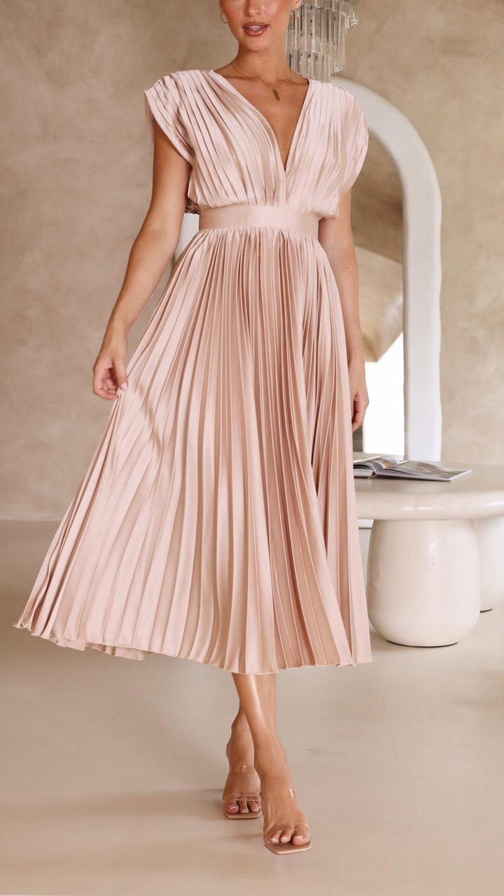 Kvindemodel viser den flydende, plisserede maxikjole frem, perfekt for en elegant sommerstil.