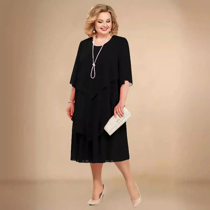 Elegant plus size chiffon festkjole til kvinder. Knælang damekjole med asymmetrisk design, perfekt til aftenbrug.