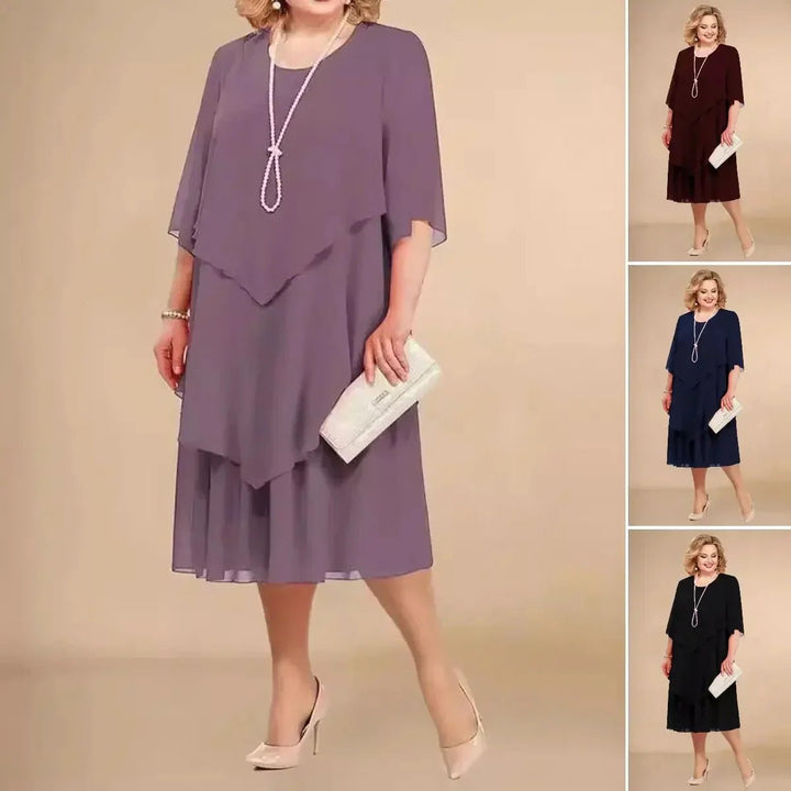 Plus size elegant damekjole i chiffon med asymmetrisk fald. Knælang festkjole for kvinder i stor størrelse.